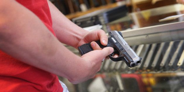TINLEY PARK, IL - JUNE 16: A customer shops for a handgun at Freddie Bear Sports on June 16, 2014 in Tinley Park, Illinois. In a 5-4 decision the Supreme Court ruled that it is a crime for one person to buy a gun for another while lying to the dealer about who the gun is for. The law had been challenged by retired police officer Bruce Abramski who was charged with making a 'straw purchase' after buying a gun for his uncle, a lawful gun owner, in order to get a police discount at the dealer. When asked on the paperwork if the gun was for him he checked yes. (Photo by Scott Olson/Getty Images)