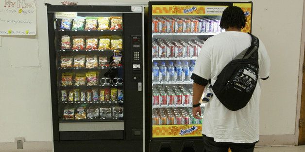 SAN FRANCISCO, CA - APRIL 8: A student buys snacks from a vending machine at Mission High School April 8, 2004 in San Francisco, California. In an effort to battle obesity in children, the San Francisco unified school district is among the first in the nation to introduce healthy vending machines in their schools which feature organic food and juice drinks. (Photo by Justin Sullivan/Getty Images)