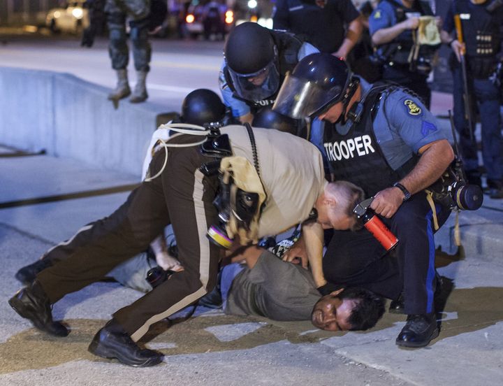 FERGUSON, UNITED STATES - AUGUST 20 : Anadolu Agency's correspondent in the U.S Bilgin Sasmaz is taken into custody by polices while he was covering protests in Ferguson, Missouri over the killing of an unarmed black teenager in United States on August 20, 2014. Bilgin Sasmaz is released after remaining in detention for 5 hours. (Photo by Samuel Corum/Anadolu Agency/Getty Images)