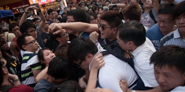 HONG KONG - OCTOBER 03: Anti-Occupy supporters clash with Occupy camp members in Causeway Bay on October 3, 2014 in Hong Kong. Thousands of pro democracy supporters continue to occupy the streets surrounding Hong Kong's Financial district. The protesters are calling for open elections and the resignation of Hong Kong's Chief Executive Leung Chun-ying, who last night agreed to hold talks with the protest leaders in a bid to diffuse the growing unrest. (Photo by Anthony Kwan/Getty Images)