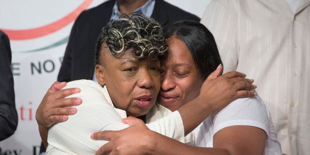 Gwen Carr, mother of Eric Garner, left, and his sister Ellisha Garner, hug during a rally at the National Action Network headquarters, Saturday, July 26, 2014, in New York. Eric Garner, 43, died on Thursday, July 18, during an arrest in Staten Island, when a plain-clothes police officer placed him in what appeared be a choke hold while several others brought him to the ground and struggled to place him in handcuffs. (AP Photo/John Minchillo)