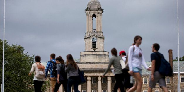 Students walk past the Old Main building on the Penn State campus Tuesday, Sept. 9, 2014, in State College, Pa. Penn State football got out from under the most severe on-field sanctions imposed on it two years ago over the Jerry Sandusky child abuse scandal, learning Monday that the NCAA will allow it to compete in this year's postseason and that all scholarships will return in 2015. (AP Photo/Matt Rourke)