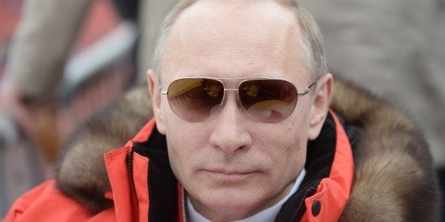 In this photo taken Saturday, March 8, 2014, Russian President Vladimir Putin watches downhill ski competition of the 2014 Wi