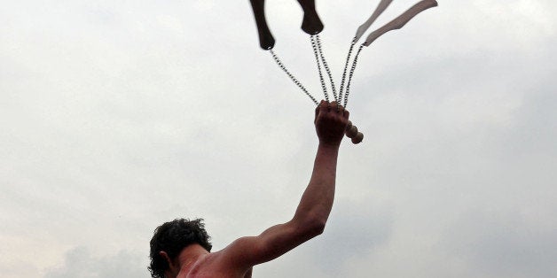 An Afghan Shiite flagellates himself with chains and knives during the holy day of Ashoura in Kabul, Afghanistan, Monday, Nov. 3, 2014. Shiites mark Ashoura, the tenth day of the month of Muharram, to commemorate the Battle of Karbala when Imam Hussein, a grandson of Prophet Muhammad, was killed. (AP Photo/Rahmat Gul)
