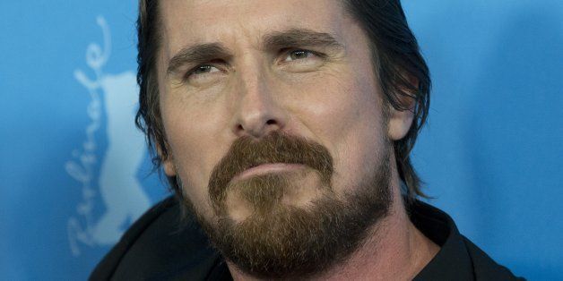 Actor Christian Bale jokingly grimaces at photographers during the photo call for the film American Hustle during the International Film Festival Berlinale, in Berlin, Friday, Feb. 7, 2014. (AP Photo/Axel Schmidt)