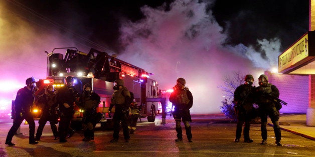 Smoke fills the streets as some buildings are on fire after the announcement of the grand jury decision Monday, Nov. 24, 2014, in Ferguson, Mo. A grand jury has decided not to indict Ferguson police officer Darren Wilson in the death of Michael Brown, the unarmed, black 18-year-old whose fatal shooting sparked sometimes violent protests. (AP Photo/Jeff Roberson)