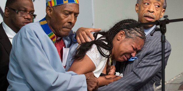 FILE - In this July 19, 2014, file photo, Esaw Garner, center, wife of Eric Garner, breaks down in the arms of Rev. Herbert Daughtry and Rev. Al Sharpton, right, during a rally at the National Action Network headquarters for Eric Garner in New York. The city medical examiner ruled that Garner died as a result of a police chokehold during an attempted arrest. Garner's family has filed a notice of claim to sue New York City, the Police Department and six individual police officers for $75 million on Monday, Oct. 6. The notice is the first step toward suing the city over Garner's death on Staten Island in July. A spokesman for city Comptroller Scott Stringer said Tuesday, Oct. 7 the claim is under review. (AP Photo/John Minchillo, File)