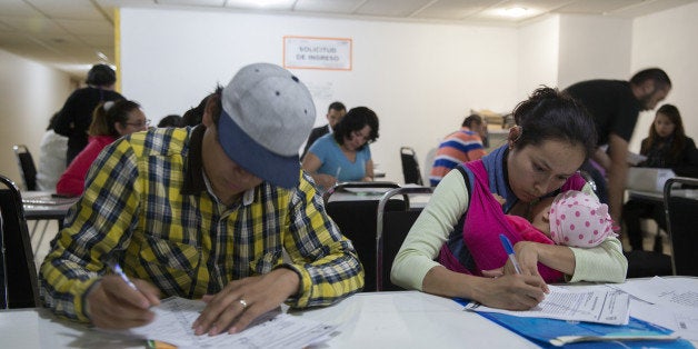 Job seekers, including a woman with a baby, right, fill out paperwork to apply for monthly unemployment insurance benefits at the Secretary of Labor's employment promotion office in Mexico City, Mexico, on Friday, Nov. 7, 2014. Mexico's unemployment rate fell to 5.08 percent in September compared with 5.18 percent in August, according to the most recent report by the national statistics agency, known as Inegi. Photographer: Susana Gonzalez/Bloomberg via Getty Images