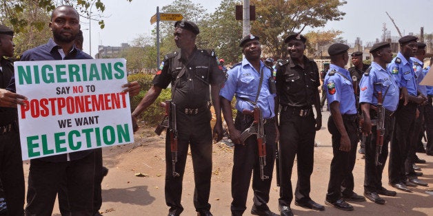 Nigerian Police provide security in Abuja, Nigeria, Saturday, Feb. 7, 2015, as people demonstrate against the possible postponement of the Nigerian elections. Civil rights groups staged a small protest Saturday against any proposed postponement. (AP Photo/Olamikan Gbemiga)