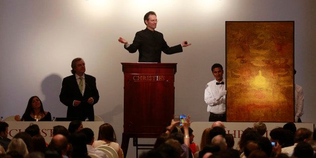 Christieâs International Director, Asian Art, Hugo Weihe, center, acts as auctioneer for the painting of Indian artist Vasudeo S. Gaitonde during Christie's first auction in India in Mumbai, India, Thursday, Dec. 19, 2013. The painting was sold for $3,280,000. Christie's held its first art auction in India on Thursday aiming to tap into a budding market for prestige purchasing among the country's fast-growing ranks of millionaires despite an economic slowdown. (AP Photo/Rafiq Maqbool)