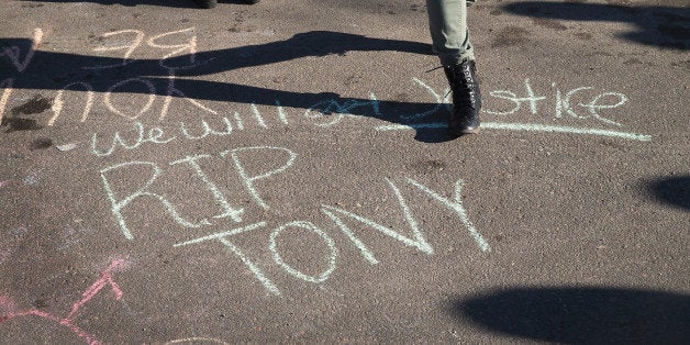 MADISON, WI - MARCH 09: Friends of 19-year-old Tony Robinson walk past a chalked memorial etched on the street outside the home where he was killed on March 9, 2015 in Madison, Wisconsin. Robinson was shot and killed by Madison Police Officer Matt Kenny during a confrontation on March 6. Robinson's death has sparked protests in the city. (Photo by Scott Olson/Getty Images)