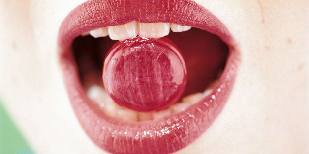 Mouth of woman biting candy