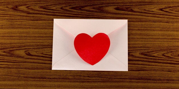 red heart with pink envelope on wooden background