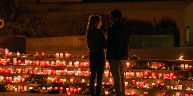 Students stand in front of candles in front of the Joseph-Koenig Gymnasium in Haltern, western Germany Tuesday, March 24, 2015. A stunned German town mourned 16 students who went down aboard Germanwings flight on their way home Tuesday from a Spanish exchange, while the opera world grieved for two singers who were returning from performing in Barcelona. (AP Photo/Martin Meissner)