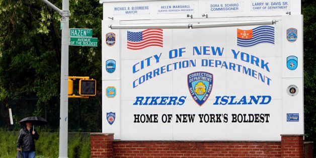 FILE - In this May 17, 2011 file photo, a man walks near the sign at the entrance to the Rikers Island jail in New York. According to a Thursday, April 3, 2014, statement by the New York City Department of Corrections, Rose Argo, the warden of the Anna M. Kross Center on Rikers Island, has been demoted and transferred to another unit that doesn't house mentally ill inmates. In February 2014, a homeless, mentally ill veteran "baked to death" in an overheated cell at the facility. (AP Photo/Seth Wenig, File)
