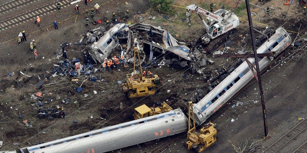 Emergency personnel work at the scene of a deadly train derailment, Wednesday, May 13, 2015, in Philadelphia. The Amtrak train, headed to New York City, derailed and crashed in Philadelphia on Tuesday night, killing at least six people and injuring dozens of others. (AP Photo/Patrick Semansky)