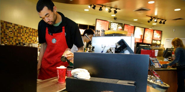 FILE - In this Nov. 24, 2014, file photo, barista Jay Rapp prepares a Chestnut Praline Latte at a Starbucks store in Seattle.