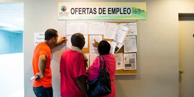 SAN JUAN, PUERTO RICO - NOVEMBER 14: People scan the bulletin board for job postings at the unemployment office on November 14, 2013 in San Juan, Puerto Rico. The unemployment rate hovers around 14 percent, almost twice the national average. The island-territory of the United States is on the brink of a debt crisis as lending has skyrocketed in the last decade with the government issuing municipal bonds. Market analysts have rated those bonds as junk and suspect it's 70 billion dollar debt might be unserviceable in the near future. With a deteriorating manufacturing industry and tourism only contributing to 10 percent of the GDP, the way out is unclear. (Photo by Christopher Gregory/Getty Images)