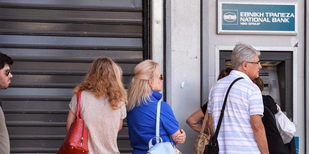 People queue at an ATM to withdraw cash in downtown Athens on July 8, 2015. Greece's government on July 8 sharply denied a newspaper report that it was readying IOUs to pay public service pensions and salaries as the country's euro cash dries up. AFP PHOTO / ANDREAS SOLARO (Photo credit should read ANDREAS SOLARO/AFP/Getty Images)