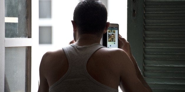 TO GO WITH AFP STORY by Laura Bonilla A Syrian refugee uses a mobile phone at an accommodation he was provided with by the Church of Sao Joao Batista in Rio de Janeiro, on September 9, 2015. As Europe struggles to deal with hundreds of thousands of migrants fleeing bloody conflicts in Syria and beyond, far-away Latin America is increasingly stepping up pledges to take in refugees. Brazil, the largest Latin American country, has taken in more Syrian refugees than any other -- more than 2,000 since the rebellion against Assad's regime began in 2011. More than four million people have fled Syria since the war began, according to the UN refugee agency (UNHCR). Another 7.6 million have been internally displaced. AFP PHOTO / VANDERLEI ALMEIDA (Photo credit should read VANDERLEI ALMEIDA/AFP/Getty Images)