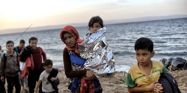 Refugees and migrants arrive at Lesbos island after crossing the Aegean Sea from Turkey on October 8, 2015. Europe is grappling with its biggest migration challenge since World War II, with the main surge coming from civil war-torn Syria. AFP PHOTO / ARIS MESSINIS (Photo credit should read DIMITAR DILKOFF/AFP/Getty Images)