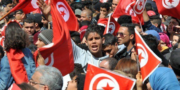 (FILES) A photo taken on March 29, 2015 shows Tunisians waving their national flag and chant slogans during a march against extremism outside Tunis' Bardo Museum. Tunisian mediators of the socalled National Dialogue Quartet (Tunisian General Labour Union UGTT, Tunisian Confederation of Industry, Trade and Handicrafts UTICA, Tunisian Human Rights League LTDH and Tunisian Order of Lawyers) won the 2015 Nobel Peace Prize, for helping to create the only democracy to emerge from the Arab Spring, at a time when the country is under threat from Islamist violence, the Norwegian Nobel Commitee announced on October 9, 2015 AFP PHOTO / FETHI BELAID (Photo credit should read FETHI BELAID/AFP/Getty Images)