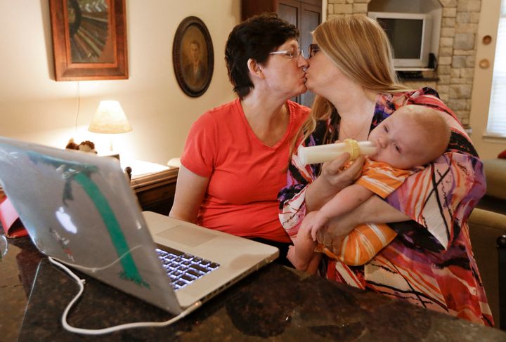 Lesbian parents kiss in Nashville on June 26, 2013, as they read the results of a Supreme Court ruling on whether same-sex couples can receive certain tax, health and pension benefits.