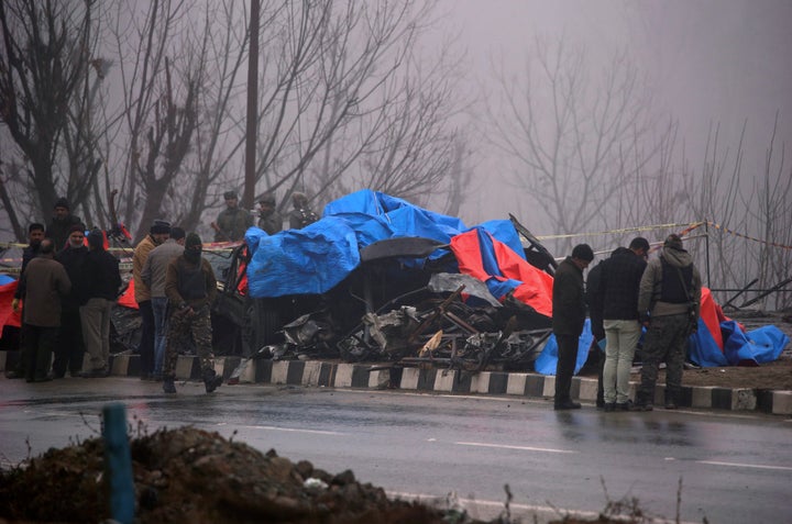 Forensic officials inspect the wreckage after the Pulwama attack.