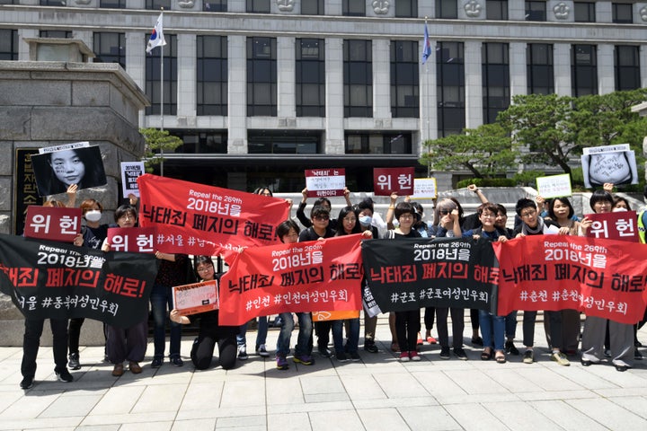 South Korean pro-choice supporters hold banners reading “Decriminalize abortions” during a rally in front of the Constitutional Court in Seoul on May 24, 2018.