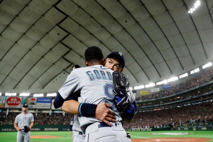 Ichiro Suzuki of the Seattle Mariners is greeted by teammate Dee Gordon after being taken out for a defensive replacement during a game against the Oakland A's during the 2019 Opening Series at the Tokyo Dome on Thursday, March 21, 2019, in Tokyo, Japan.