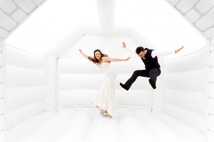 Tor and Duncan Cox jumping for joy in their wedding bouncy castle.