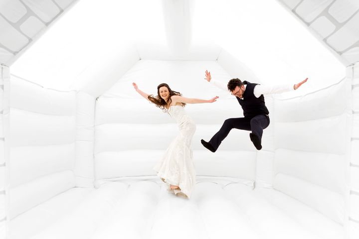 Tor and Duncan Cox jumping for joy in their wedding bouncy castle. 