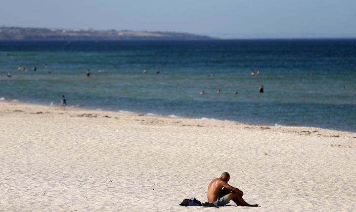 A beachgoer sits in the sun in Adelaide, Australia, in January, where temperatures reached a searing 115.9 degrees Fahrenheit.