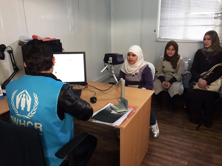 In this photo taken Sunday, Feb. 26, 2017, an 11-year-old Syrian refugee poses for a biometric iris scan in an interview room of the U.N. refugee agency in Amman, Jordan.