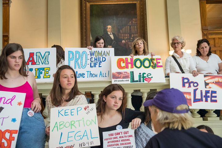 Abortion rights advocates and anti-abortion demonstrators displaying their signs in the lobby of the Georgia State Capitol on March 22.