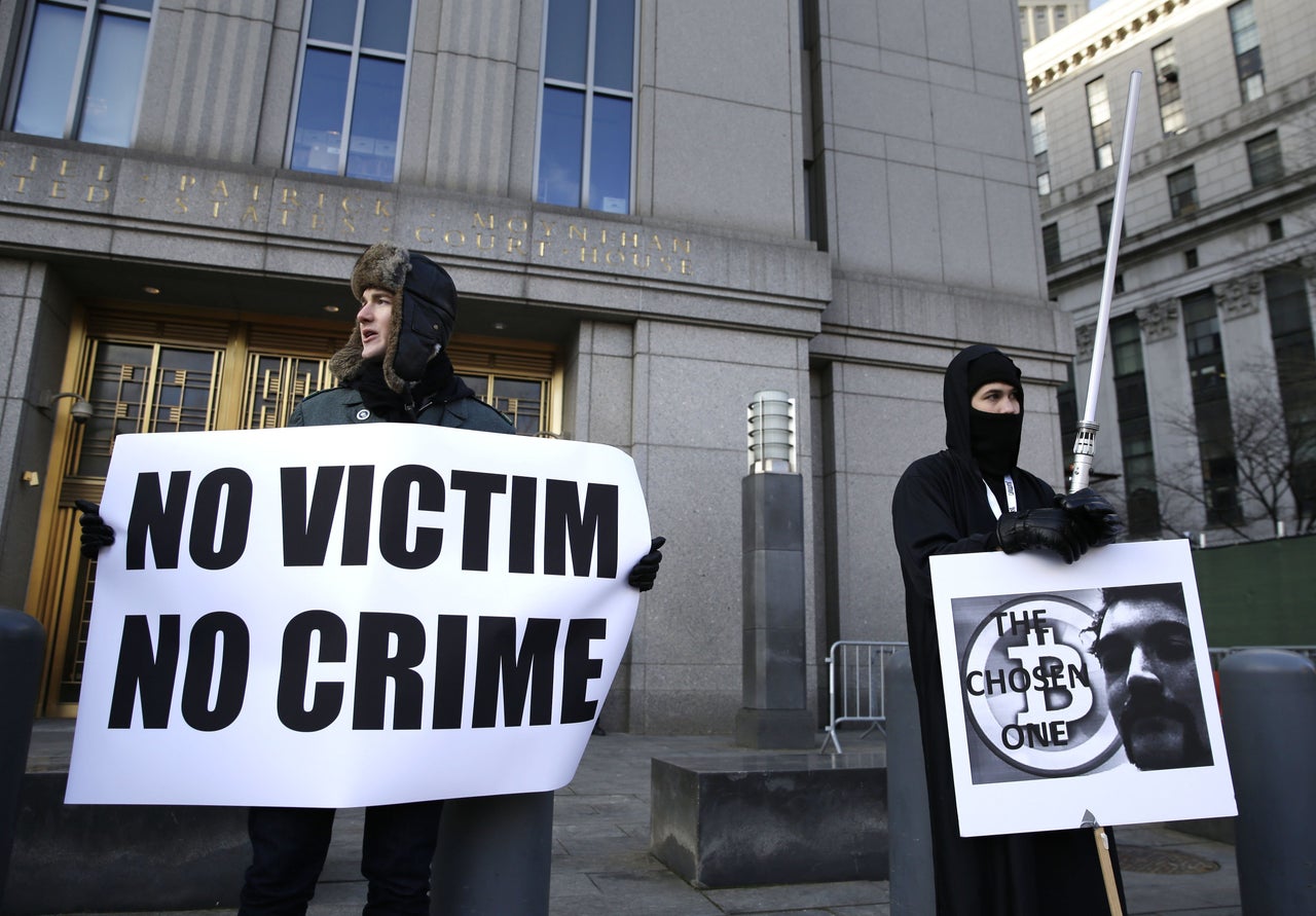 Supporters of Ross William Ulbricht hold signs during the jury selection for his trial outside of federal court in New York, Tuesday, Jan. 13, 2015. Murder-for-hire allegations are central to the trial of Ulbrichtt, charged with running an online black market where drugs were sold as easily as books and electronics. 