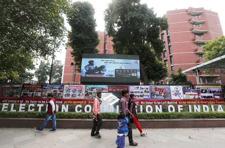 People walk past the Election Commission of India office building in New Delhi, March 11, 2019. 