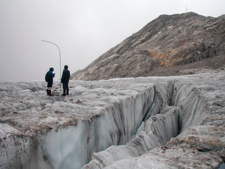 This Sept. 22, 2018 photo shows researchers measuring with iron bars the annual retreat of the Baishui Glacier No.1 on the Jade Dragon Snow Mountain in the southern province of Yunnan in China. (AP Photo/Sam McNeil)