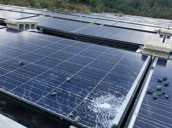 A shattered Tesla solar panel outside a water facility.