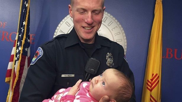 An Albuquerque police officer holds his newly adopted daughter, whose birth mother used heroin while she was pregnant. Babies and toddlers are entering the foster care system at a higher rate, possibly because of the opioid crisis.