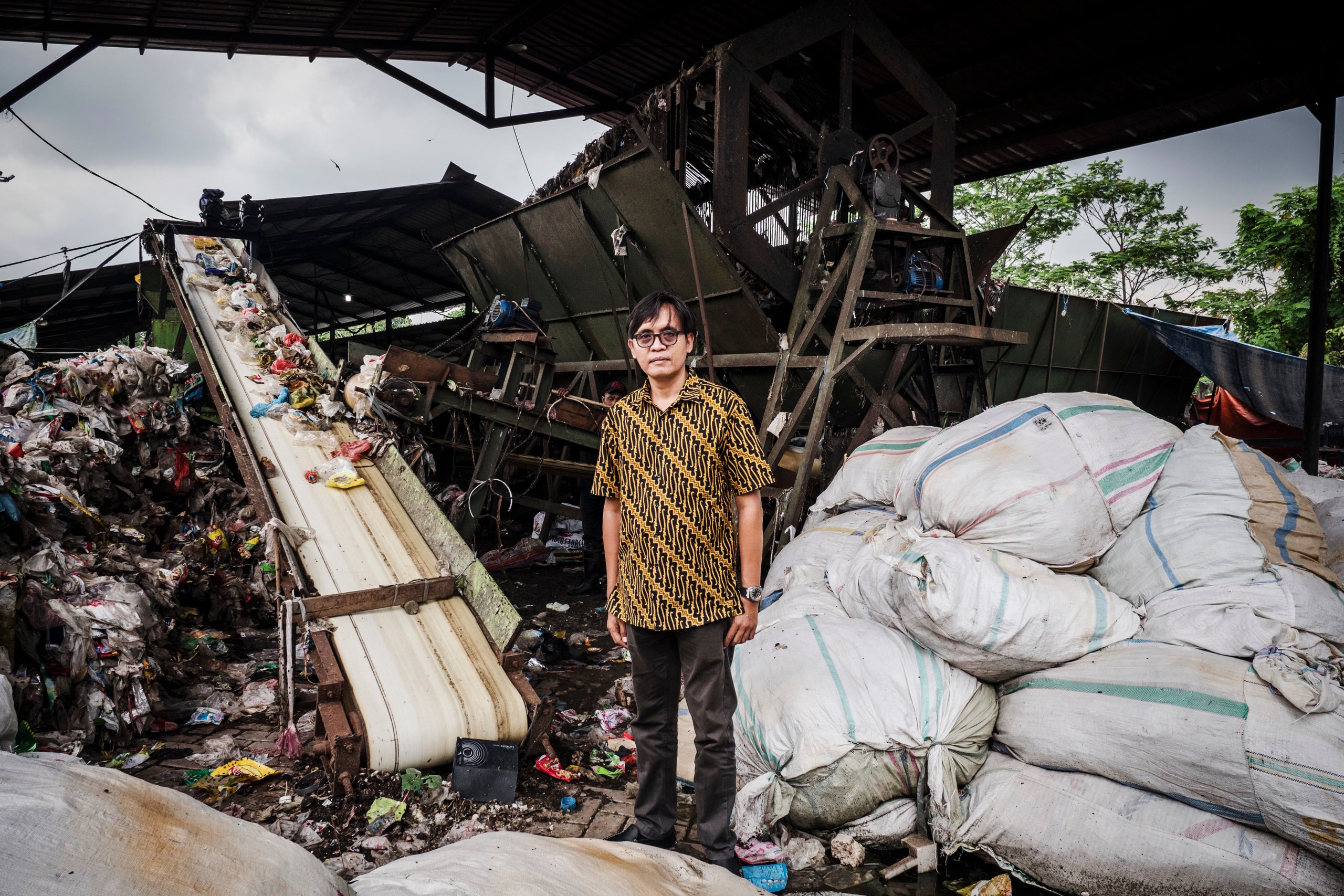 Bhima Diyanto, an ecologist and director of a waste management company, poses at a mechanical sorting center where neighborho