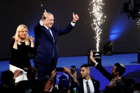 Israeli Prime Minister Benjamin Netanyahu and his wife Sara react as they stand on stage following the announcement of exit polls in Israel's parliamentary election at the party headquarters in Tel Aviv, April 10, 2019.
