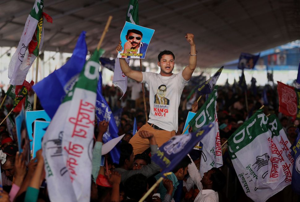 A participant displays a picture of Dalit leader Chandrasekhar Azad as supporters of BSP, SP and RLD gather during an election rally in Deoband on April 7, 2019. 
