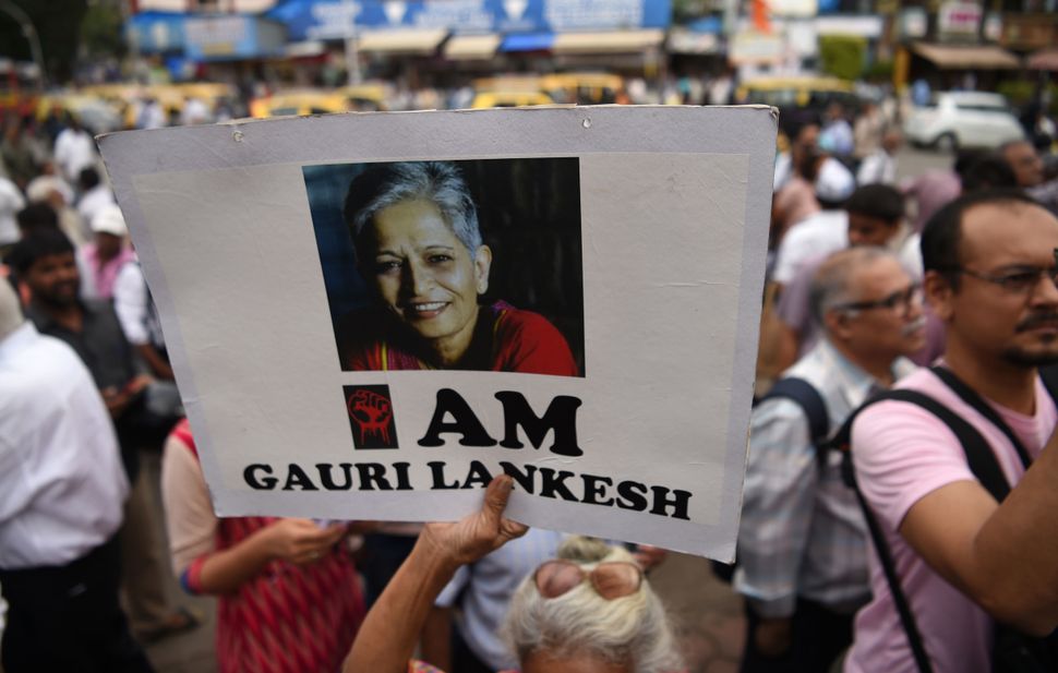 A woman holds a poster of murdered editor Gauri Lankesh on her first death anniversary during a protest in Mumbai on September 5, 2018.