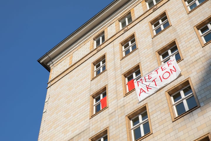 Tenants protest the sale of apartments in several housing complexes along Berlin's Karl-Marx-Alee by hanging banners and flags outside their windows with slogans such as "tenant action."