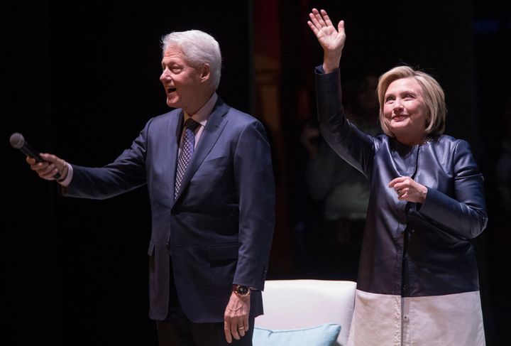 Former President Bill Clinton and former Secretary of State Hillary Clinton wave at the crowd as they arrive on stage Thursday night for "An Evening With the Clintons" at the Beacon Theatre in New York.