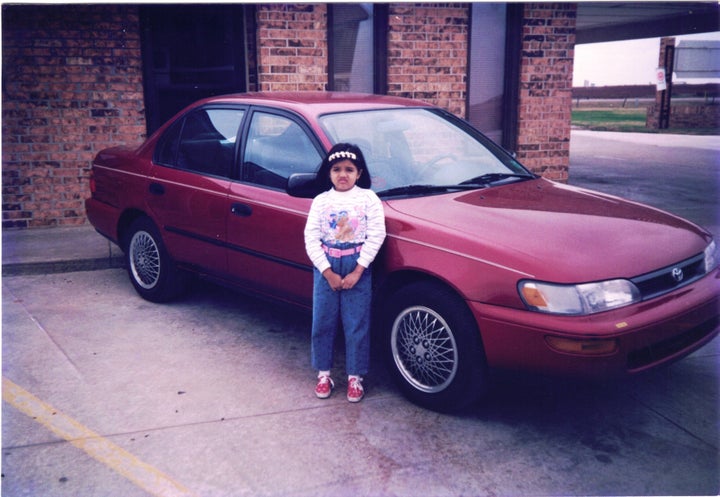 The author, around 5 or 6 years old, standing in front of the family car in rural Oklahoma in front of the motel her parents&
