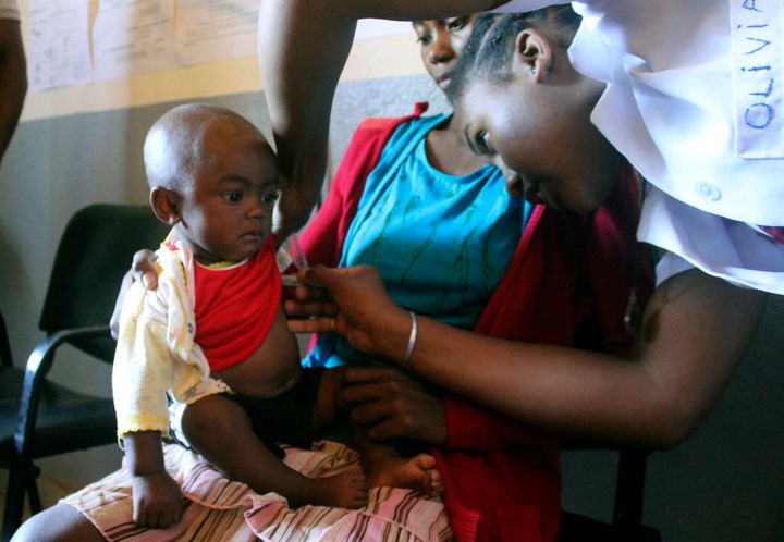 A volunteer nurse at a health care center in Larintsena, Madagascar, examines a 6-month-old who has measles while her mother, Nifaliana Razaijafisoa, looks on. 