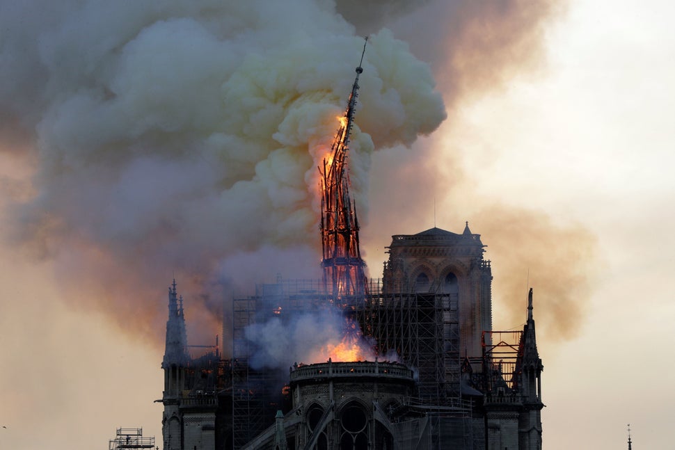 The steeple of the landmark Notre Dame Cathedral collapses as the cathedral is engulfed in flames in central Paris on April 1