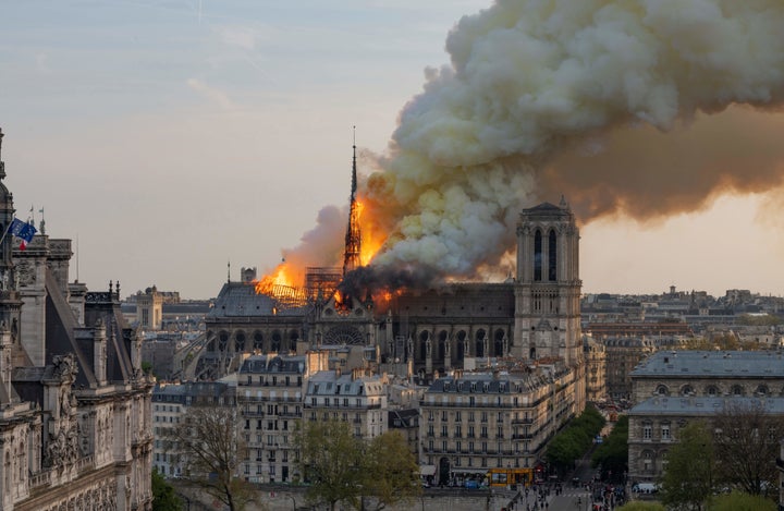 Smoke billows as flames burn through the roof of Notre Dame on Monday. (Photo by Fabien Barrau / AFP)